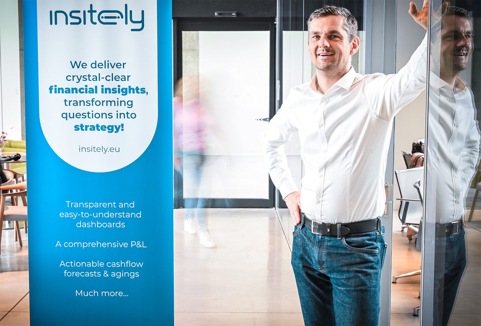 Roel B&auml;umer of Insitely beside an Insitely roll-up banner